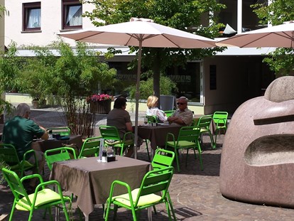 Monteurwohnung - Einzelbetten - Hessen Süd - Außenansicht mit Café-Bistro "Midde Noi" - Gästezimmer-Michelstadt