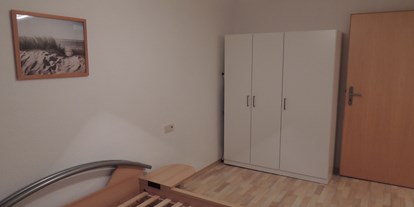 Monteurwohnung - PLZ 35708 (Deutschland) - Schlafzimmer bestehend aus einem Bett (1,40 x 2 m) und einem dreitürigen Schrank, Bettwäsche inklusive. - Monteur-Apartment