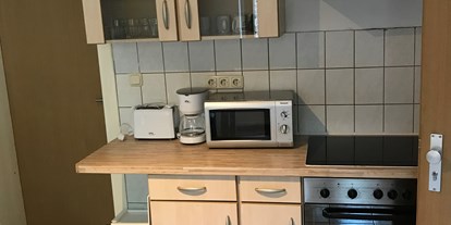 Monteurwohnung - Frechen - Küchenzeile mit Mikrowelle, Kaffeemaschine und Herd /Backofen - Palms Zimmer