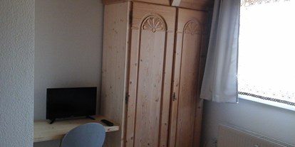 Monteurwohnung - Küche: Küchenmitbenutzung - Stuttgart / Kurpfalz / Odenwald ... - Schrank und Tisch mit Stuhl und TV im Doppelzimmer - Haus Johann