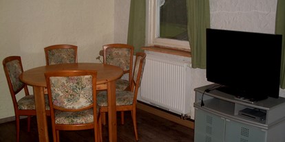Monteurwohnung - Zimmertyp: Mehrbettzimmer - Baiersbronn direkt in Baiersbronn - Esstisch mit Stühlen und Fernseher -  Monteurwohnung Nordschwarzwald