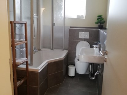 Monteurwohnung - Kühlschrank - PLZ 97839 (Deutschland) - Badezimmer mit Badewanne und Duschabtrennung im Monteurzimmer in Triefenstein. - Spessart-T-Raum - Monteurzimmer