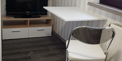 Monteurwohnung - Badezimmer: eigenes Bad - Brüheim - TV Tisch und Stuhl  - Bause 