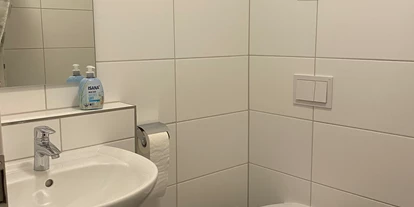 Monteurwohnung - WLAN - Baden-Württemberg - Bad mit Toilette und Dusche links vom Bild.  - Monteurzimmer Spatz