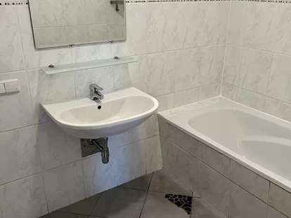 Monteurwohnung - Kühlschrank - PLZ 8301 (Österreich) - Badezimmer mit Waschbecken und Badewanne in der Monteurunterkunft in Dobl-Zwaring. - Azra Sinanovic