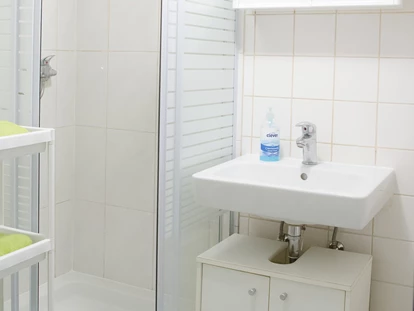 Monteurwohnung - WLAN - Niederschöckl - Badezimmer mit Waschbecken und Dusche in der Monteurunterkunft in Graz. - Monteurzimmer-Monteurwohnung-Arbeiterwohnung in Graz 
