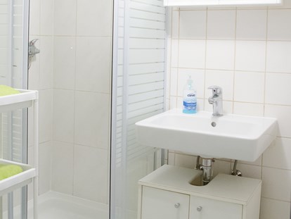 Monteurwohnung - Einzelbetten - Mantscha - Badezimmer mit Waschbecken und Dusche in der Monteurunterkunft in Graz. - Monteurzimmer-Monteurwohnung-Arbeiterwohnung in Graz 
