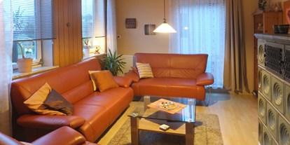Monteurwohnung - Lügde - Wohnzimmer mit Kachelofen - Ferienwohnung "Alte Leibzucht" in Emmerthal