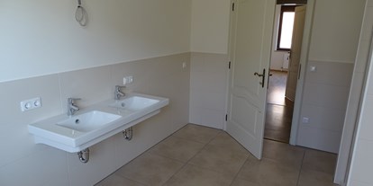 Monteurwohnung - Höllwiesen - Bad ist ausgestattet mit Dusche, Badewanne, Doppelwaschbecken, Seifenspender, Toilettartikelschrank, Waschmaschine und Wäschetrockner - Refugia Wels