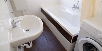 Monteurwohnung - Badezimmer: Gemeinschaftsbad - Pottiga - Bad mit Badewanne und Waschmaschine - HoSl Gemütliches Monteurzimmer in Hof – Ideal für Ihren Arbeitsaufenthalt!