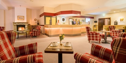 Monteurwohnung - Edermünde - Lobby mit Rezeption, gemütlichen Sitzbereichen und Kaminecke im Waldhotel Schäferberg - Gästehaus Waldeslust 