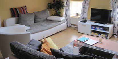 Monteurwohnung - Bettwäsche: Bettwäsche inklusive - Bad Schwartau - Wohnraum aus Blick der Küche. Die linke Couch lässt sich zusätzlich zum Bett ausziehen - Ferienhof March