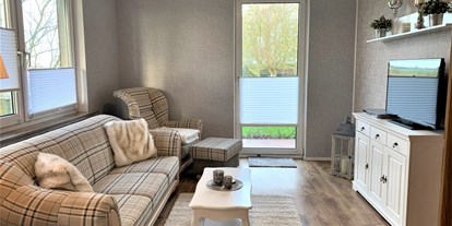 Monteurwohnung - WLAN - PLZ 26954 (Deutschland) - Wohnzimmer mit Couch, Sessel und TV. Zugang zur Terrasse. - ANDY NORDSEE: 2 Schlafzimmerwohnung im Urlaubsparadies