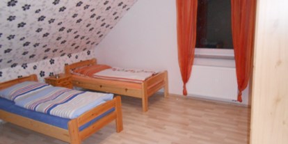 Monteurwohnung - Kühlschrank - Ravenstein - große Schlafzimmer mit Einzelbetten aus Naturholz mit passenden Nachtischen und Kleiderschränken - Gästehaus Böres