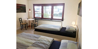 Monteurwohnung - Kühlschrank - Klein Offenseth-Sparrieshoop - Eines unserer zwei Doppelzimmer mit Tisch und Stühlen im Nordhaus A7 bei Hamburg - Nordhaus A7 bei Hamburg