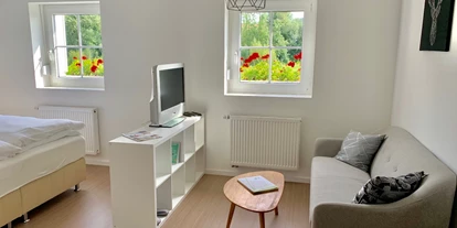 Monteurwohnung - WLAN - PLZ 91166 (Deutschland) - Der Wohnbereich mit Couch und Fernseher mit HD-Digitalempfang. - Business- & Ferienwohnung Tietze