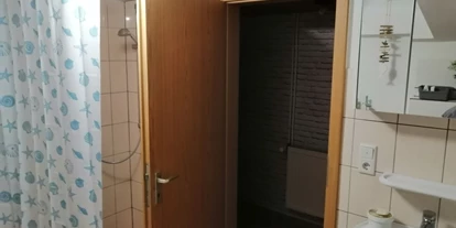 Monteurwohnung - Kaffeemaschine - PLZ 26676 (Deutschland) - Badezimmer aus der Sicht der Toilette hinter der Tür befindet sich die Dusche, links daneben die Waschmaschine mit eingebautem Trockner. Ca 5qm. - Haus Else