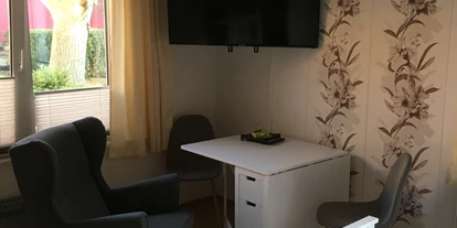 Monteurwohnung - Bettwäsche: Bettwäsche inklusive - Hüttenrode - Fernseher mit Sitzbereich im eigentlichen Zimmer - Apartment Wernigerode