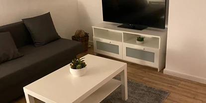 Monteurwohnung - Kühlschrank - Georgsdorf - Wohnzimmer mit Fernseher - Appartement Sütthoff