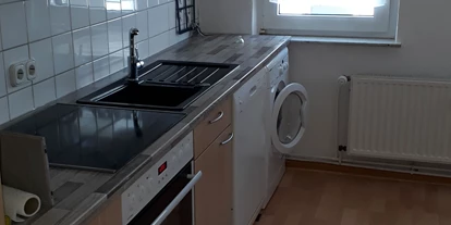 Monteurwohnung - WLAN - Pegestorf - Küche und Esszimmerbereich mit Abstellkammer für Müll, Wäscheständer, Bügelbrett usw. - Appartment Bad Pyrmont