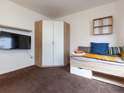 Monteurwohnung - Zimmertyp: Mehrbettzimmer - Kleiderschrank und Einzelbett und Bildschirm - Kleeblatt