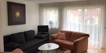 Monteurwohnung - Einzelbetten - PLZ 78343 (Deutschland) - Wohnzimmer mit Schlafsofa und Zugang zum Balkon - Ferienwohnung Creutzig