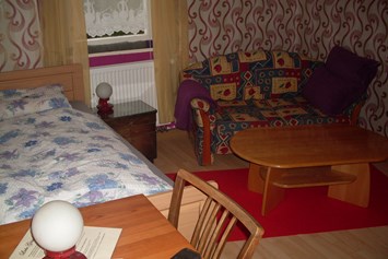 Monteurwohnung: Einzelbett, Couch und Couchtisch -  Monteurwohnung Nordschwarzwald