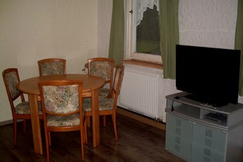 Monteurwohnung: Esstisch mit Stühlen und Fernseher -  Monteurwohnung Nordschwarzwald
