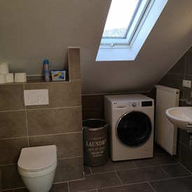 Monteurzimmer: Badezimmer mit WC und Waschmaschine im Monteurzimmer Spessart-T-Raum in Triefenstein. - Spessart-T-Raum - Monteurzimmer