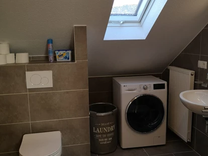 Monteurwohnung - TV - Deutschland - Badezimmer mit WC und Waschmaschine im Monteurzimmer Spessart-T-Raum in Triefenstein. - Spessart-T-Raum - Monteurzimmer