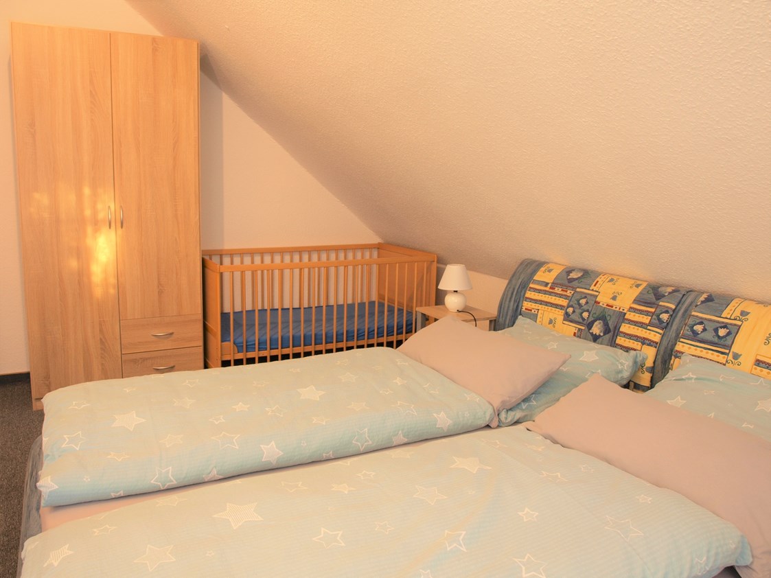 Monteurzimmer: Schlafzimmer mit Kinderbett - Große Whg. m. 3 Schlafz., Bad/Dusche m. WC, Küche m. Vollausst., Wohnraum mit FLA-TV, W-LAN 