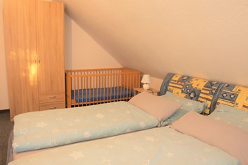 Monteurzimmer: Schlafzimmer mit Kinderbett - Große Wohnung mit 3 Schlafzimmern, Bad/Dusche, Küche 