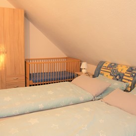 Monteurzimmer: Schlafzimmer mit Kinderbett - Große Wohnung mit 3 Schlafzimmern, Bad/Dusche, Küche 