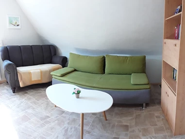 Monteurzimmer: Wohnzimmer mit kleiner Sitzcouch und Schlafsofa (hier finden 2 Personen Platz) - Ferienwohnung-Fulda