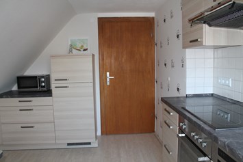 Monteurzimmer: andere Seite der Küche mit Kühl- Gefrierkombination und Microwelle - Ferienwohnung-Fulda