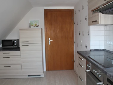 Monteurzimmer: andere Seite der Küche mit Kühl- Gefrierkombination und Microwelle - Ferienwohnung-Fulda