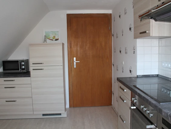 Monteurzimmer: andere Seite der Küche mit Kühl- Gefrierkombination und Microwelle - Ferienwohnung-Fulda