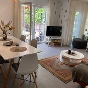 Monteurwohnung: Wohnzimmer mit Essbereich, Schlafcouch, Flat screen und kostenloses WLan sowie Zugang zur Terrasse und Garten - Kerstin Schilling