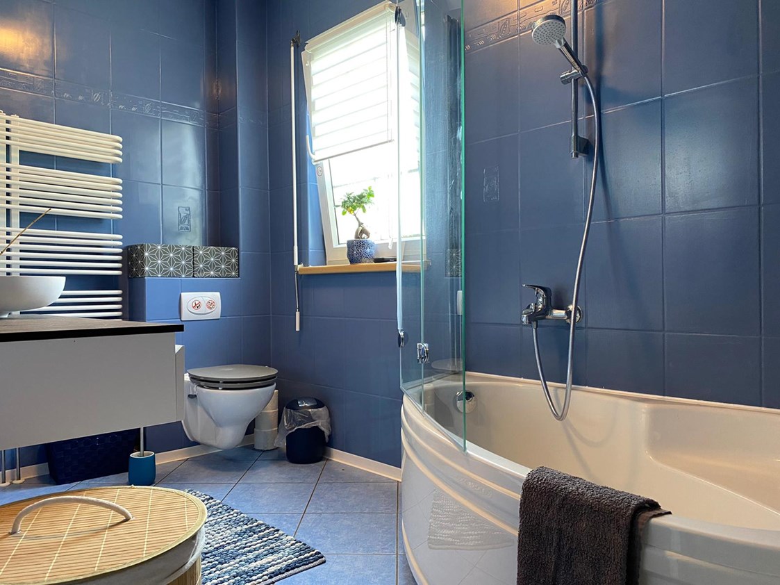 Monteurzimmer: Badezimmer Obergeschoss mit Badewanne und Duschhalterung mit Glasspritzschutz, Toilette und Waschtisch - Kerstin Schilling