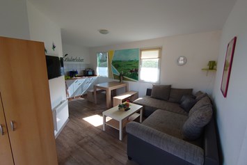 Monteurzimmer: Wohnbereich Schlafcouch - Oase am See Heimat Bungalows