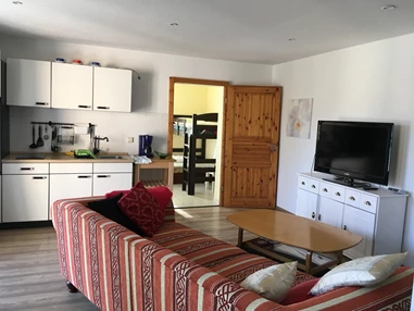 Monteurzimmer: Küchenzeile und im Hintergrund ein Raum mit Hochbett und Liege -davon ab geht es zum Badezimmer mit Dusche , WC und Waschbecken - Ferienwohnung Seeblick