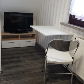 Monteurzimmer: TV Tisch und Stuhl  - Bause 