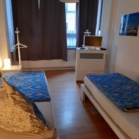 Monteurzimmer: Schlafzimmer mit Einzelbetten und Fernseher in der Monteurwohnung Bremerhaven. - Sleepspot Bremerhaven 