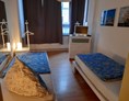 Monteurzimmer: Schlafzimmer mit Einzelbetten und Fernseher in der Monteurwohnung Bremerhaven. - Sleepspot Bremerhaven 