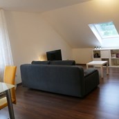 Monteurzimmer - Das geräumige Wohnzimmer mit Essecke lädt dazu ein, den Feierabend zu genießen - guest apartment niederalfingen // Aalen-Ellwangen-Heidenheim-Schwäbisch Gmünd