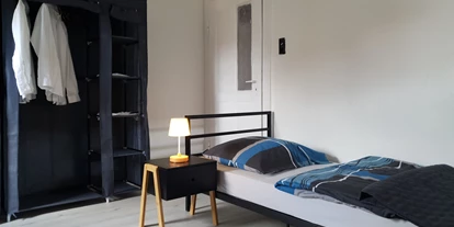 Monteurwohnung - Northeim - Einzelbett mit Nachttisch - Beata Holz