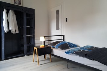 Monteurzimmer: Einzelbett mit Nachttisch - Beata Holz