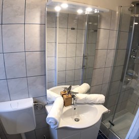 Monteurzimmer: Helles Badezimmer mit Dusche der Monteurwohnung in Graz. - Monteurzimmer/Monteurwohnung in Graz