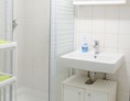 Monteurzimmer: Badezimmer mit Waschbecken und Dusche in der Monteurunterkunft in Graz. - Monteurzimmer-Monteurwohnung-Arbeiterwohnung in Graz 