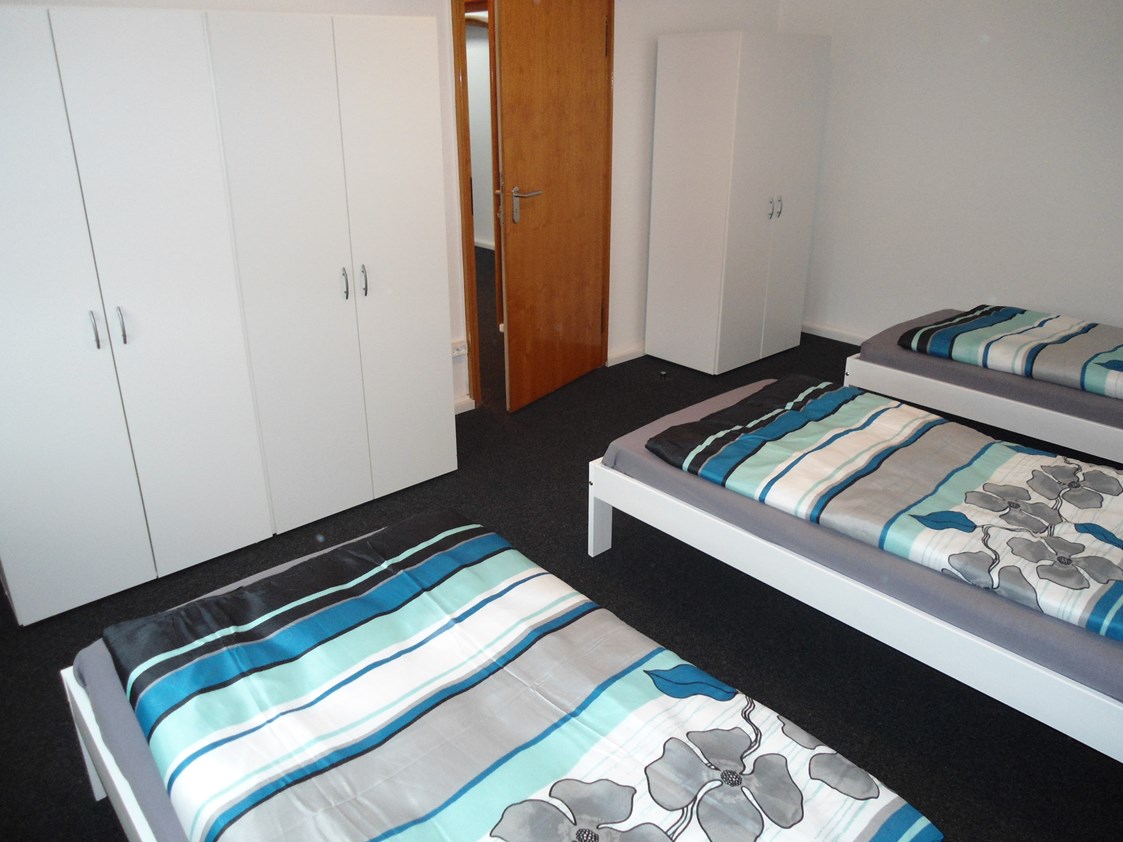 Monteurzimmer: Zimmer 3 mit Einzelbetten und Kleiderschränken in der Monteurunterkunft in Wolfsburg. - BSK-Monteurunterkünfte